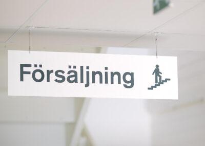 Takhängd hänvisningsskylt inomhus